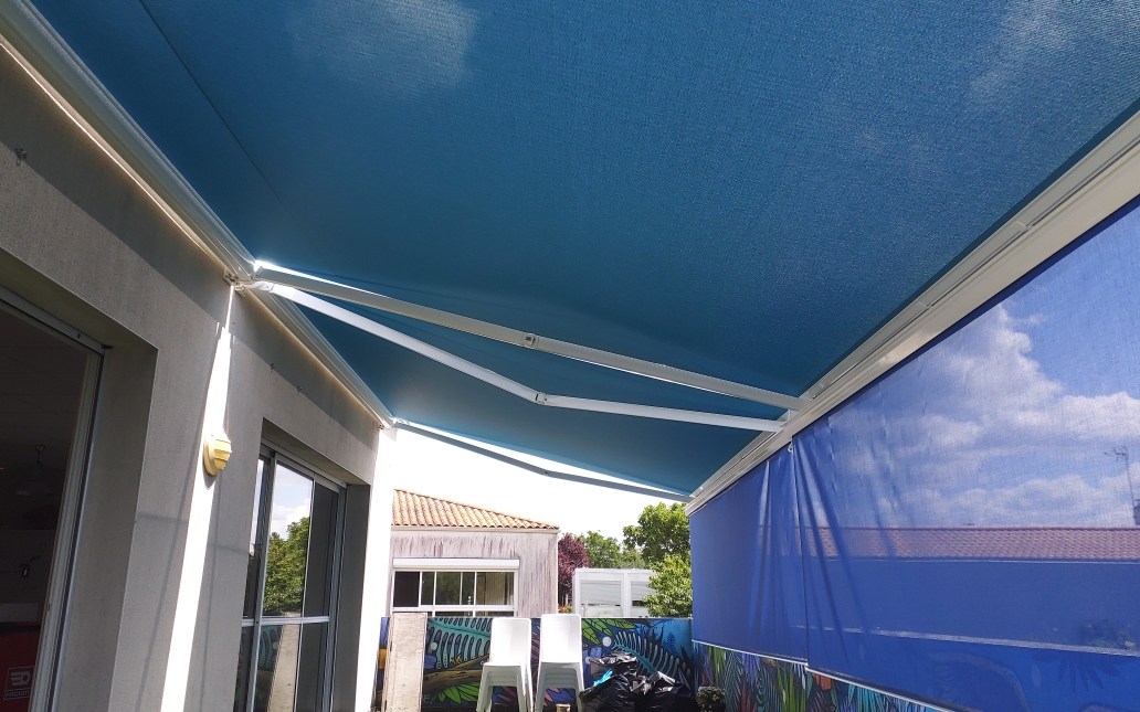 Store banne bleu déployé avec store vertical — terrasse Vendée